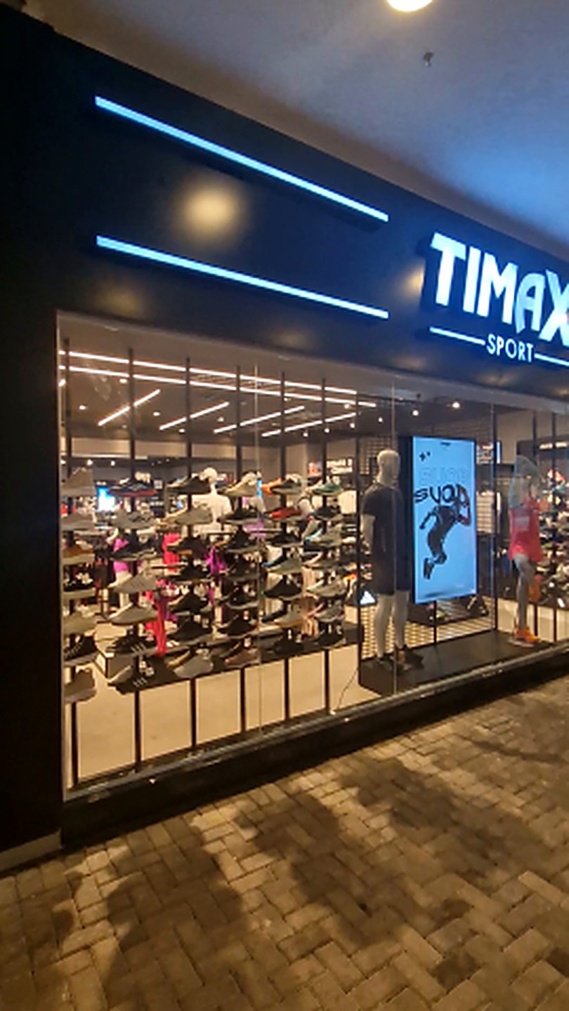 Fachada iluminada e vitrine digital da loja Timax Sport
